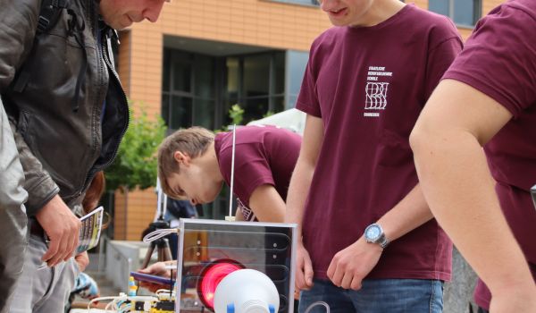 Ein Jugendliche erklären Experimente für Interessierte.