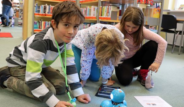 Kinder programmieren einen Roboter.