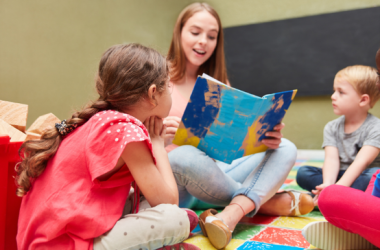 Junge Frau liest Kindern aus einem Buch vor, Foto: Robert Kneschke