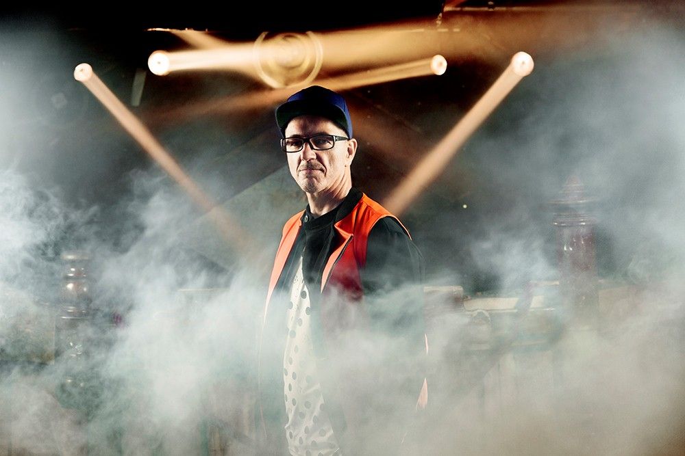 Ein Mann ist umgeben von Nebel. Im Hintergrund leuchten Scheinwerfer.