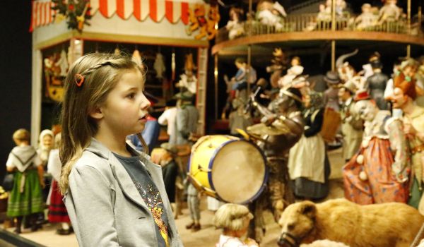 Ein Kind schaut sich die alte Zirkusausstellung im Spielzeugmuseum an.