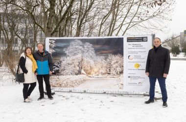 Zwei Männer und eine Frau stehen neben einem großen Banner. Einer der Männer ist der Hauptamtliche Beigeordente Christian Dressel.