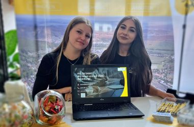 Zwei junge Frauen stehen hinter einem Infostand. Es sind Auszubildende der Stadt Sonneberg.