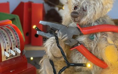 Ein Teddy-Bär hält eine Zange.