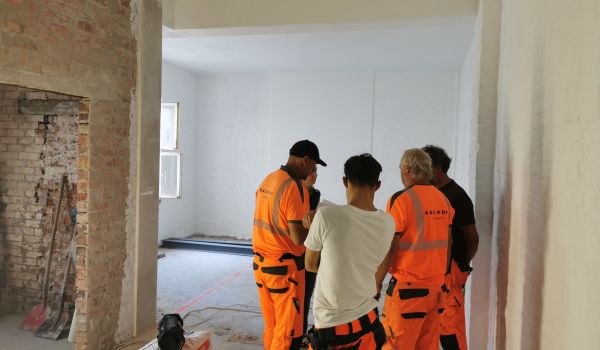 Fünf Personen auf einer Baustelle.