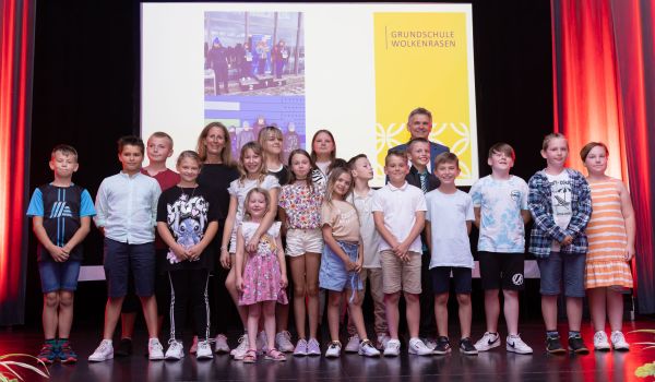 Kinder stehen auf einer Bühne.