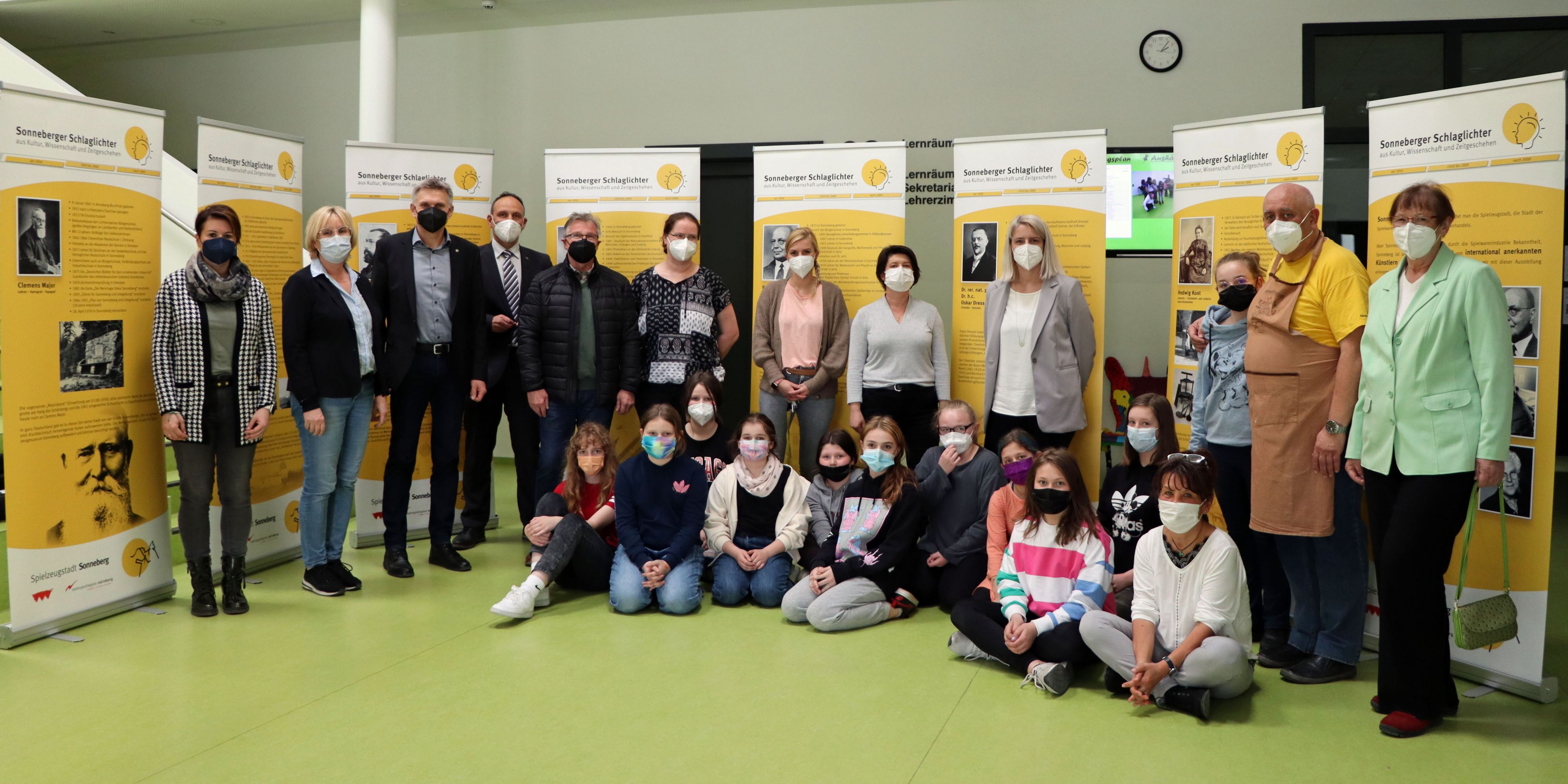 Eine Gruppe von Menschen vor veschiedenen Bannern.