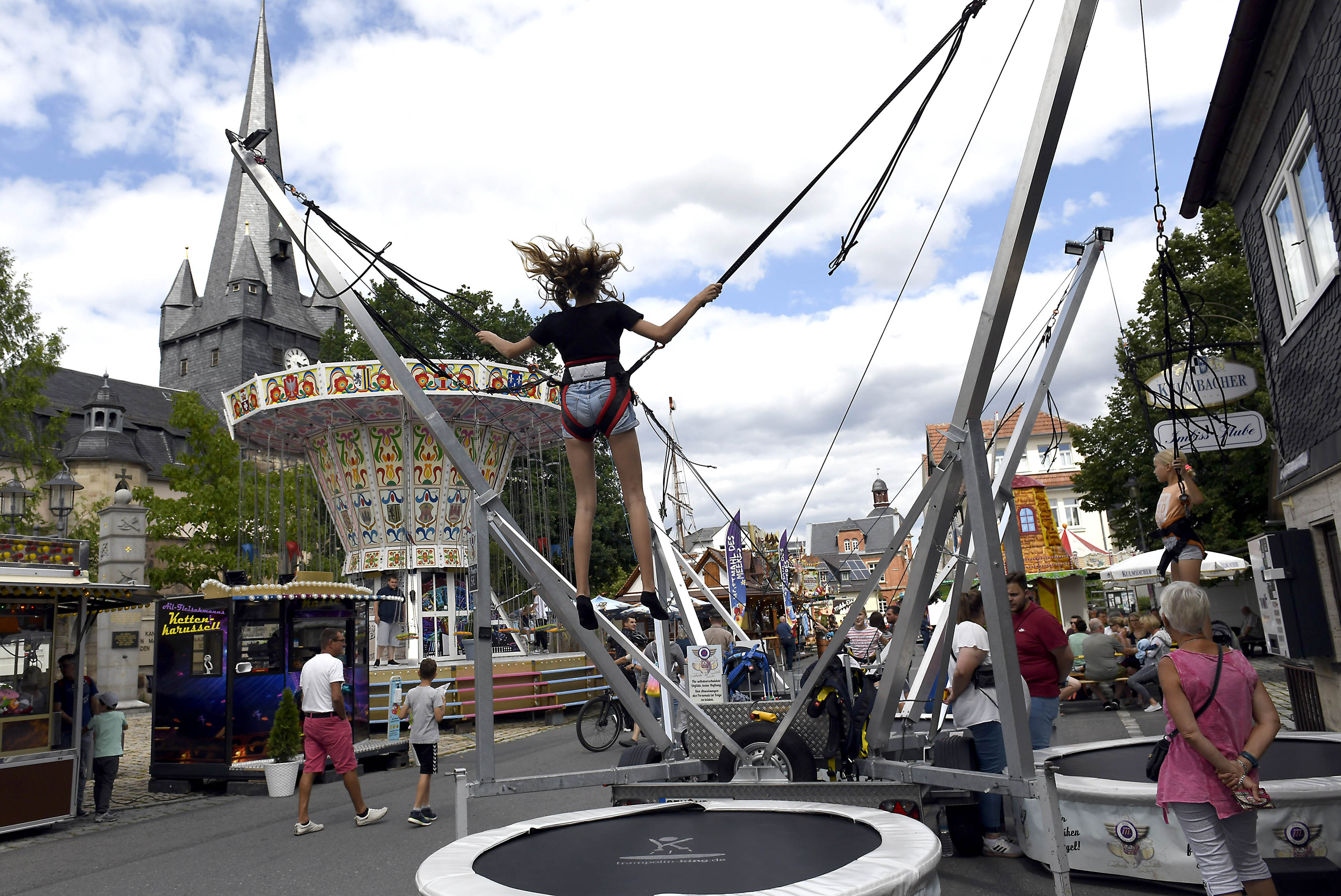 Ein Platz mit verschiedenen Fahrgeschäften und Verkaufsständen.