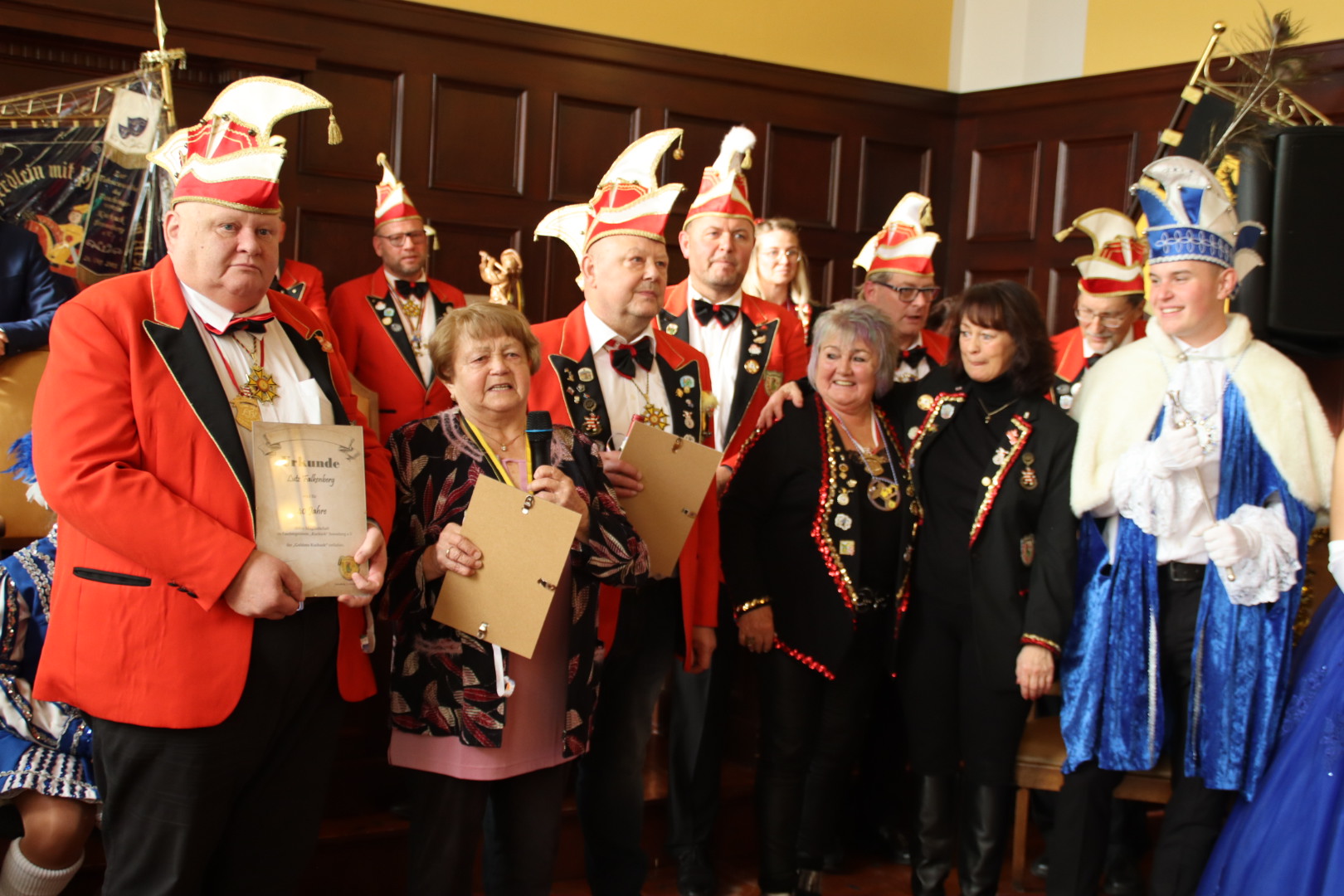 Der Elferrat hält Urkunden in Fotorahmen in der Hand.