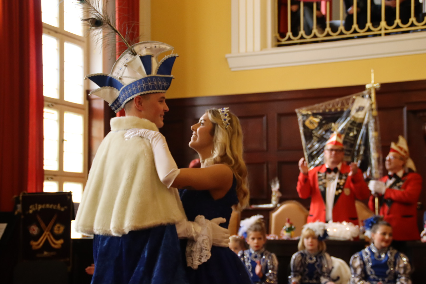 Das Prinzenpaar tanzt. Im Hintergrund klatscht der Elferrat.