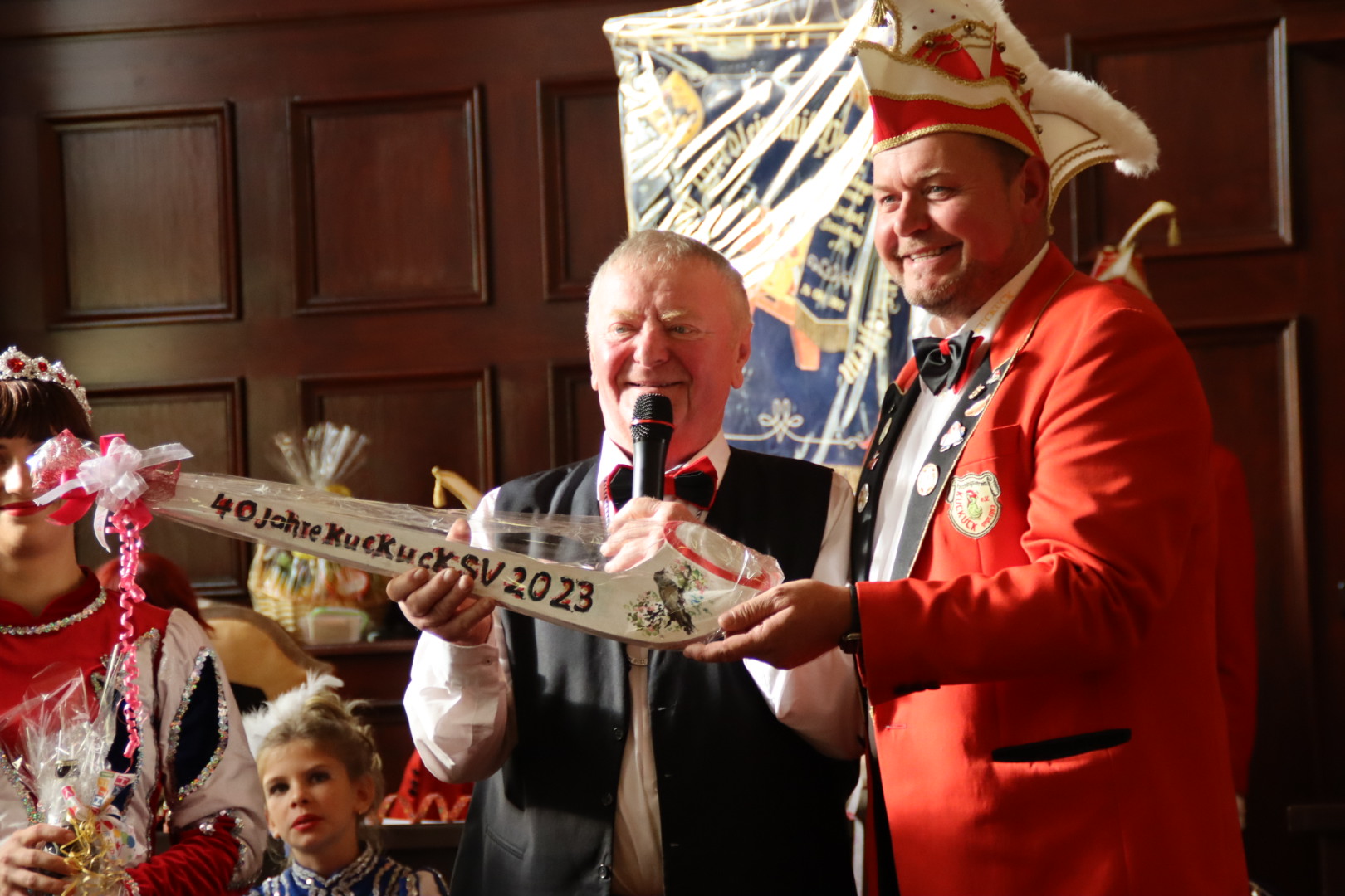 Ein Mitglied des Elferrats hält ein Präsent mit der Aufschrift: 40 Jahre KuckuckSV 2023.