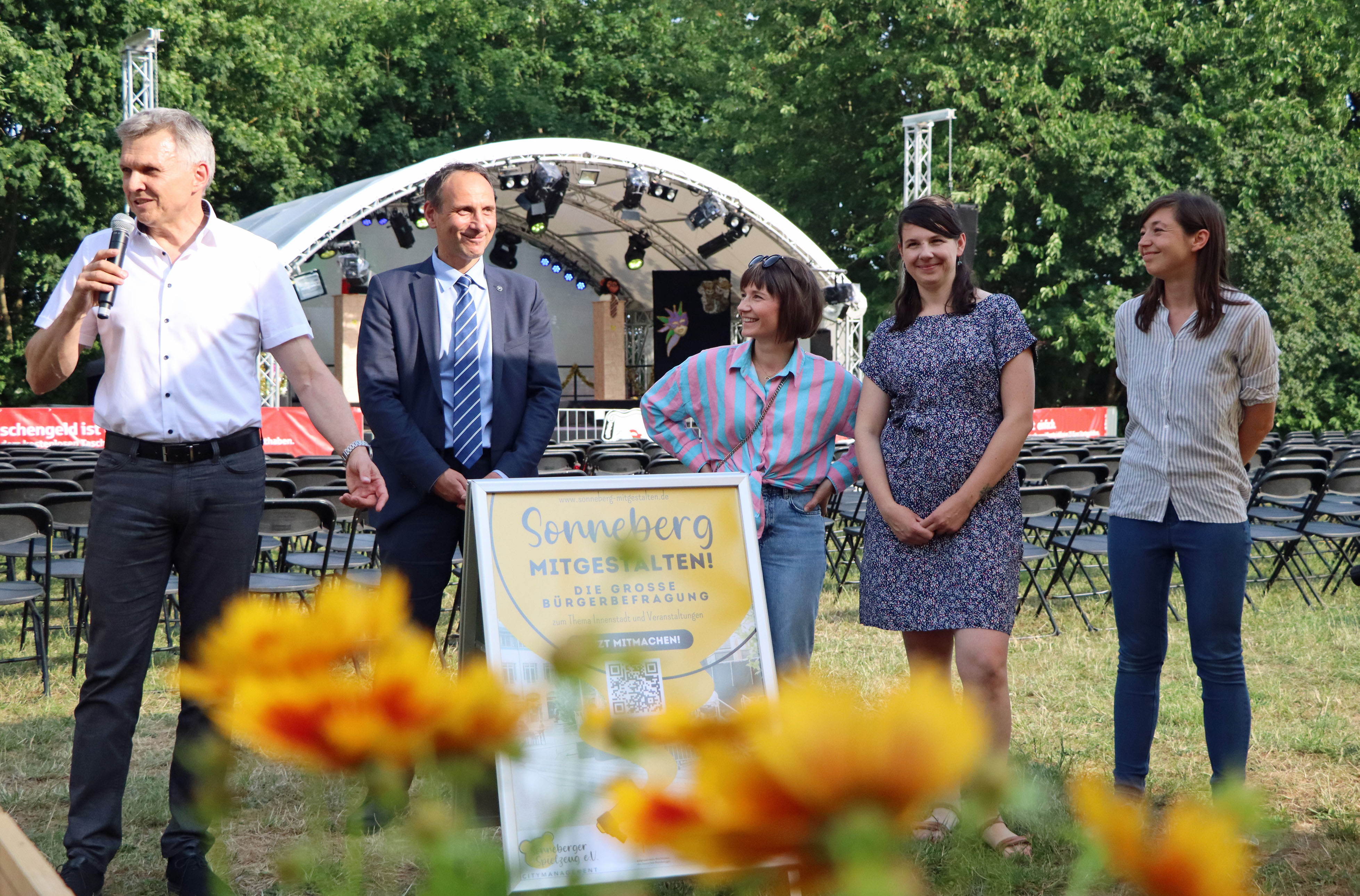 Fünf Personen stehen auf einer Wiese und begrüßen die Gäste.