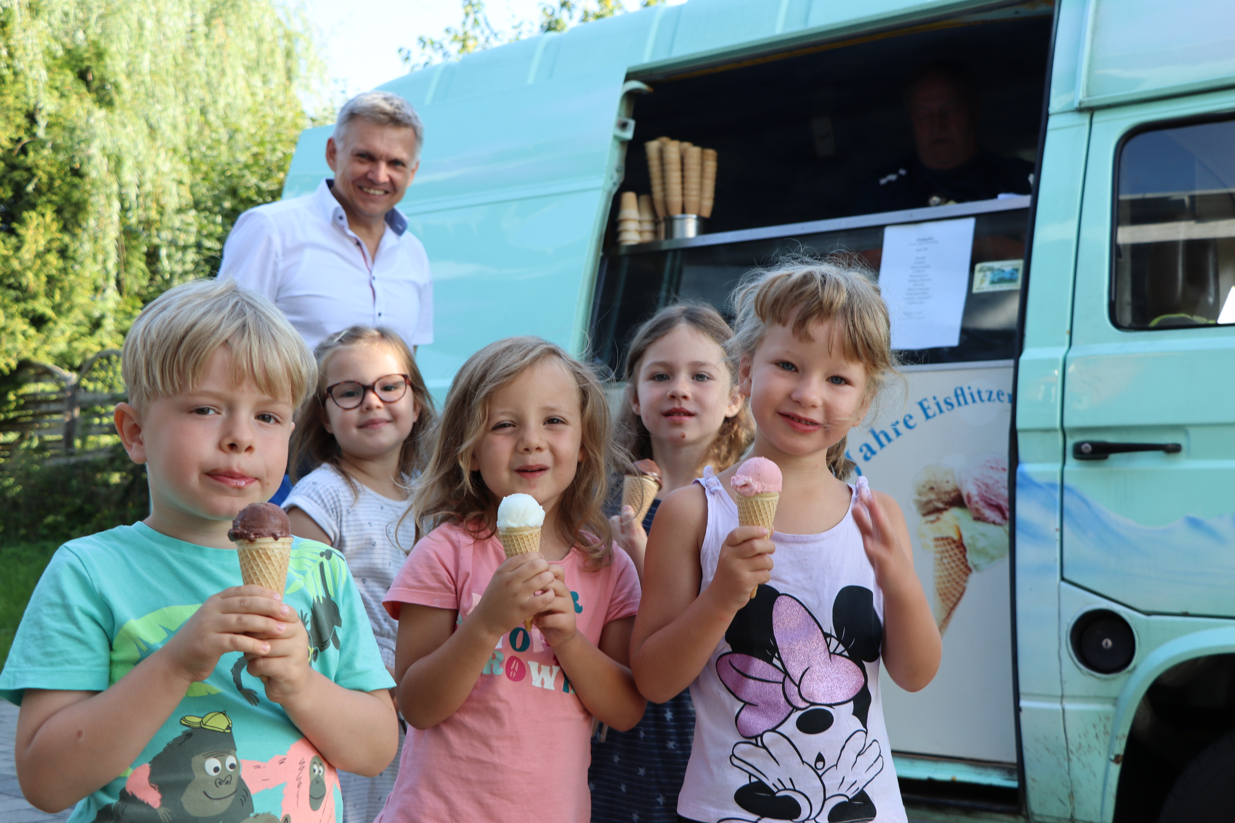 Kinder stehen vor einem Eisauto.