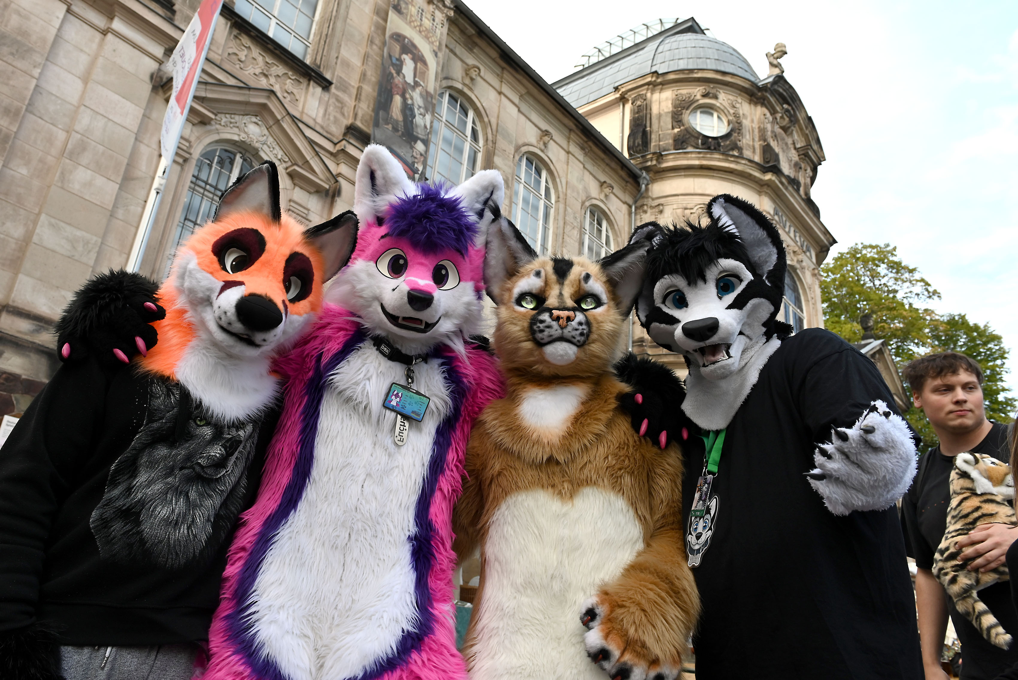 Vier Personen in Tierkostümen aus Plüsch stehen vor einem alten Sandstein-Gebäude. Es ist das Spielzeugmuseum der Stadt Sonneberg.