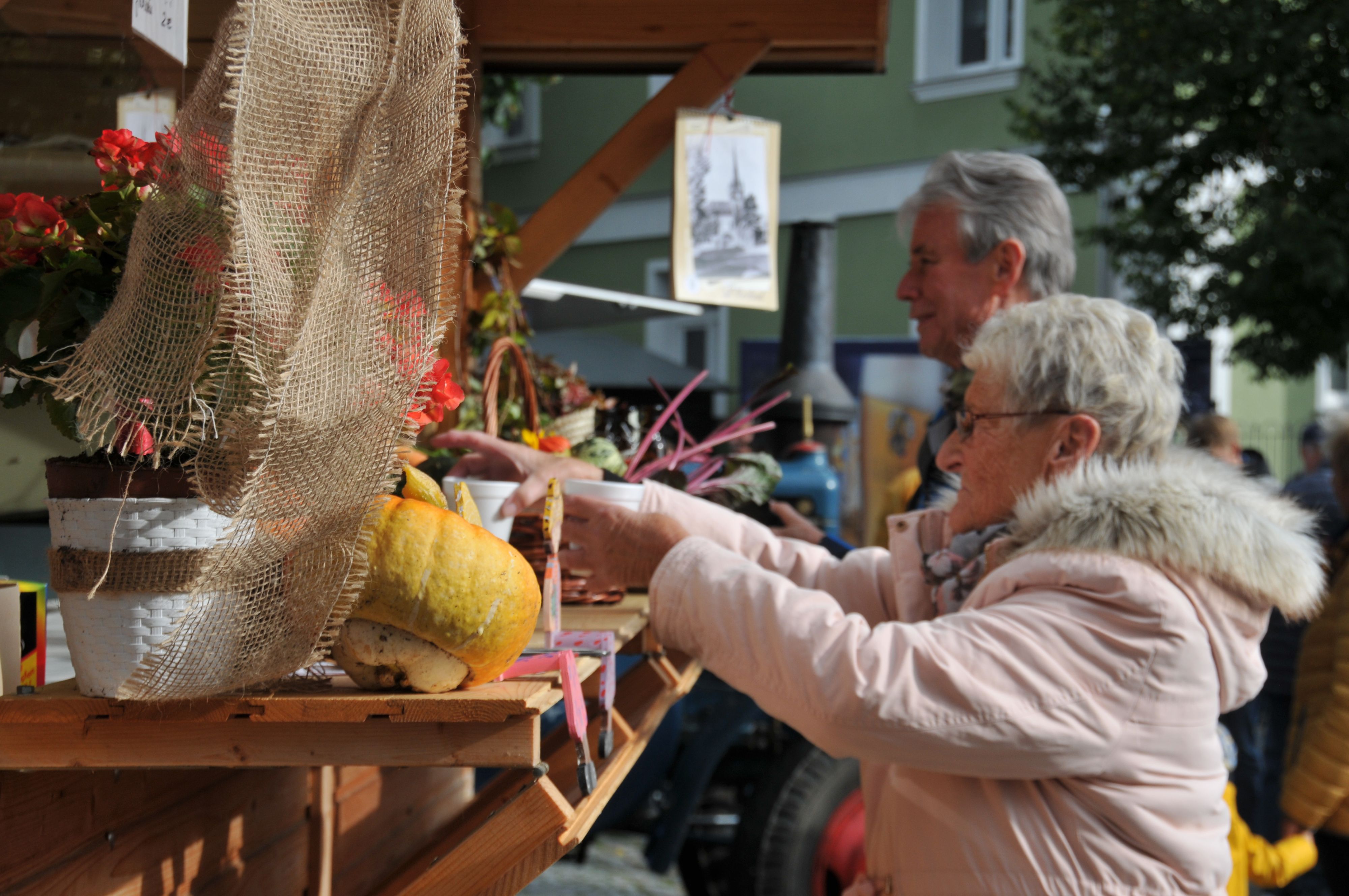 Eine Frau nimmt zwei Getränke-Becher von einer Theke.