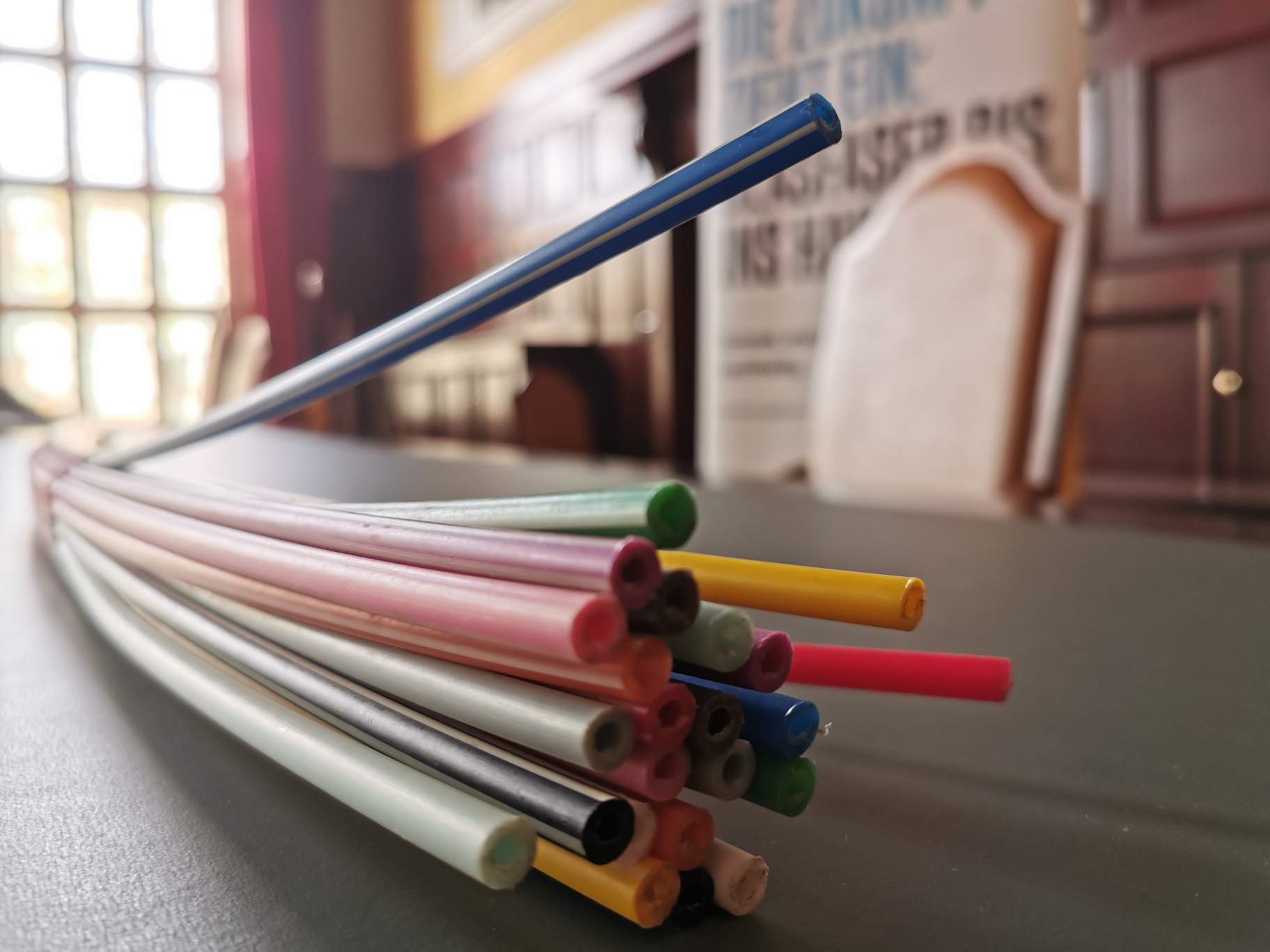 Mehrere bunte, trinkhalmähnliche Kabel liegen auf einem Tisch im Rathaussaal.