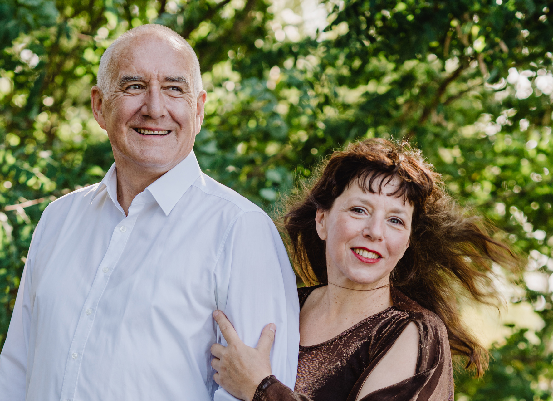 Eine Frau und ein Mann stehen in einem Wald.