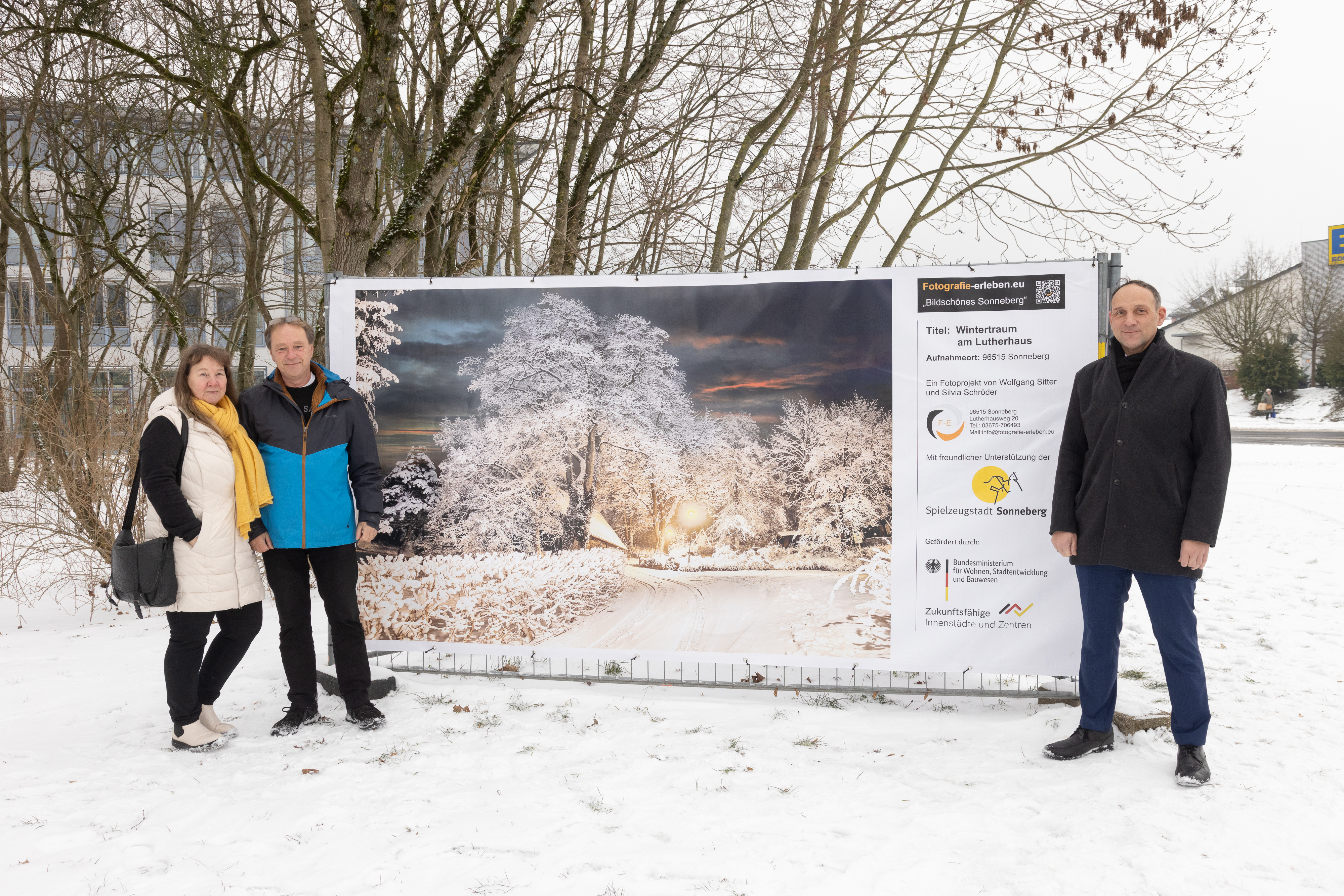 Zwei Männer und eine Frau stehen neben einem großen Banner. Einer der Männer ist der Hauptamtliche Beigeordente Christian Dressel.