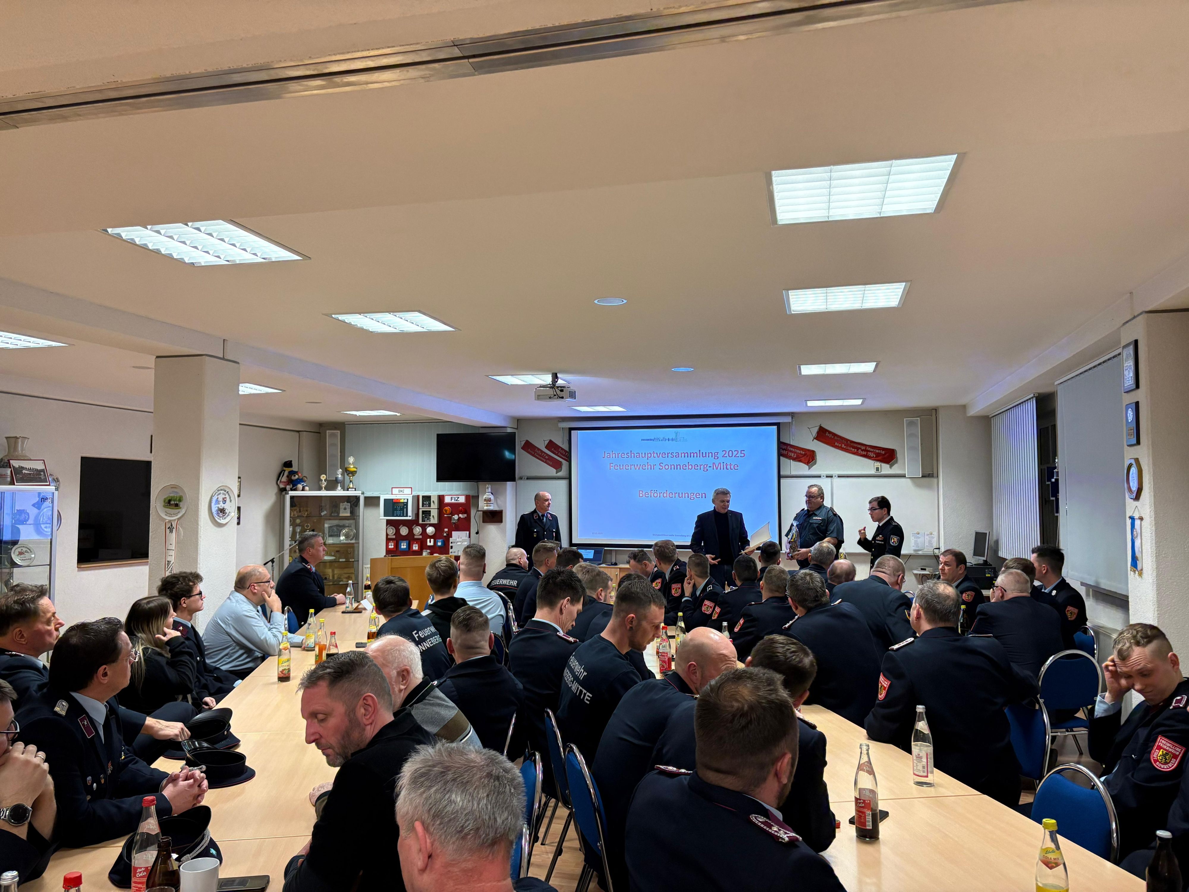 Blick in einen Saal mit vielen Feuerwehrkameraden.