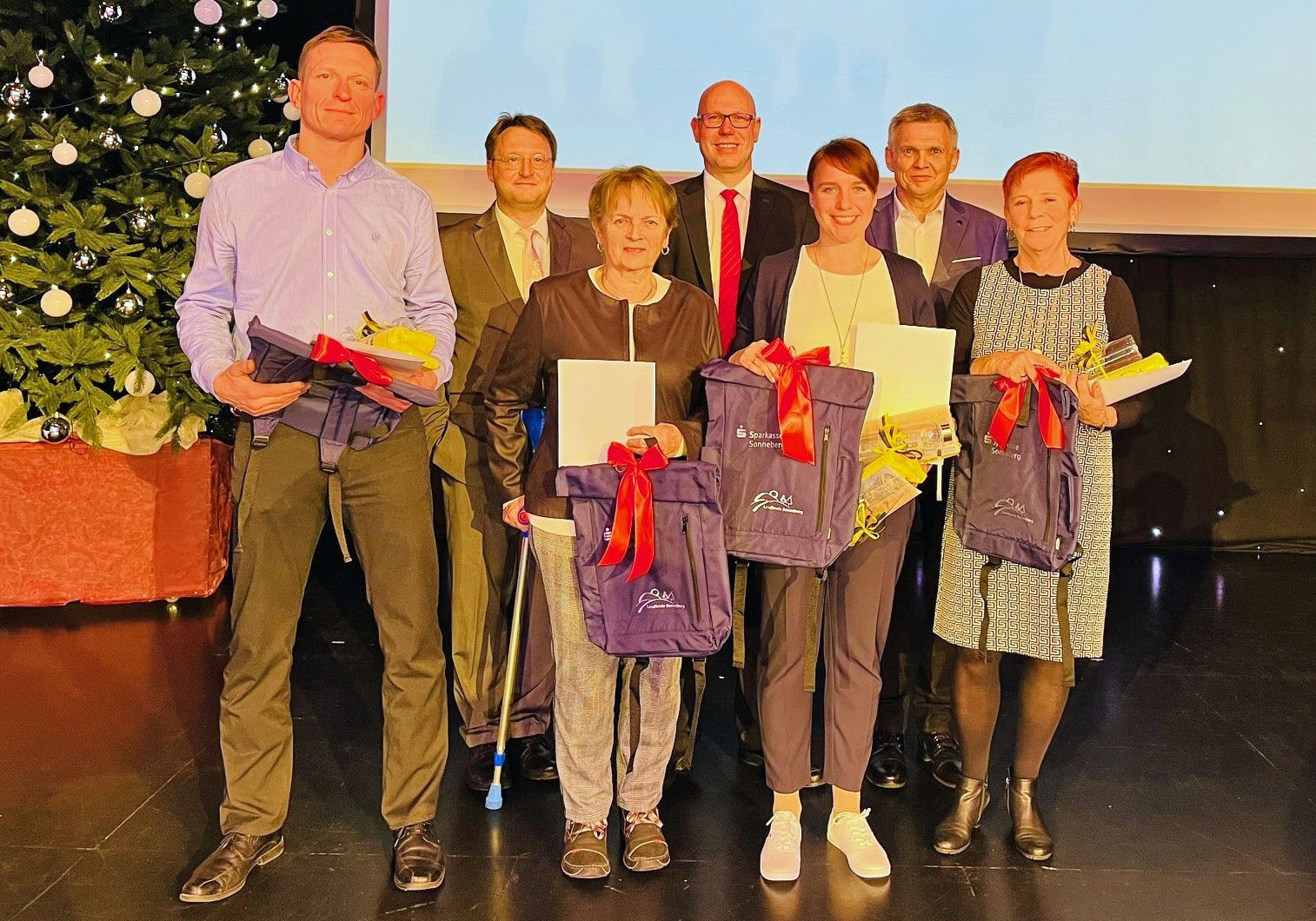 Männer und Frauen stehen auf einer Bühne anlässlich einer Sportlergala.