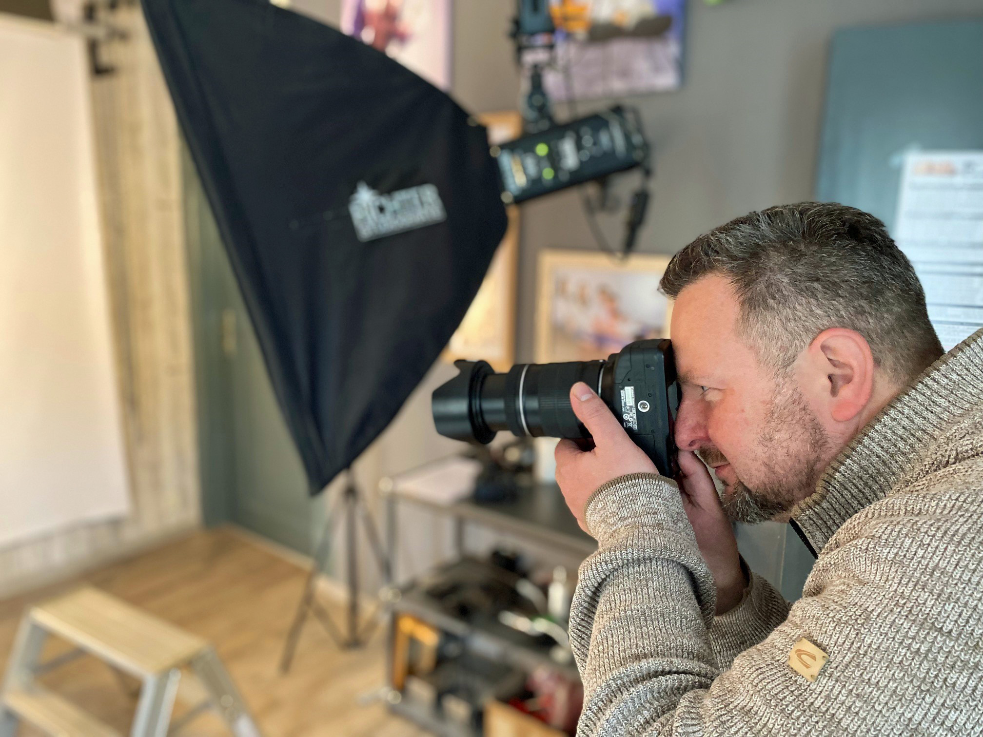 Ein Fotograf mit einer Kamera fotografiert in einem Studio.