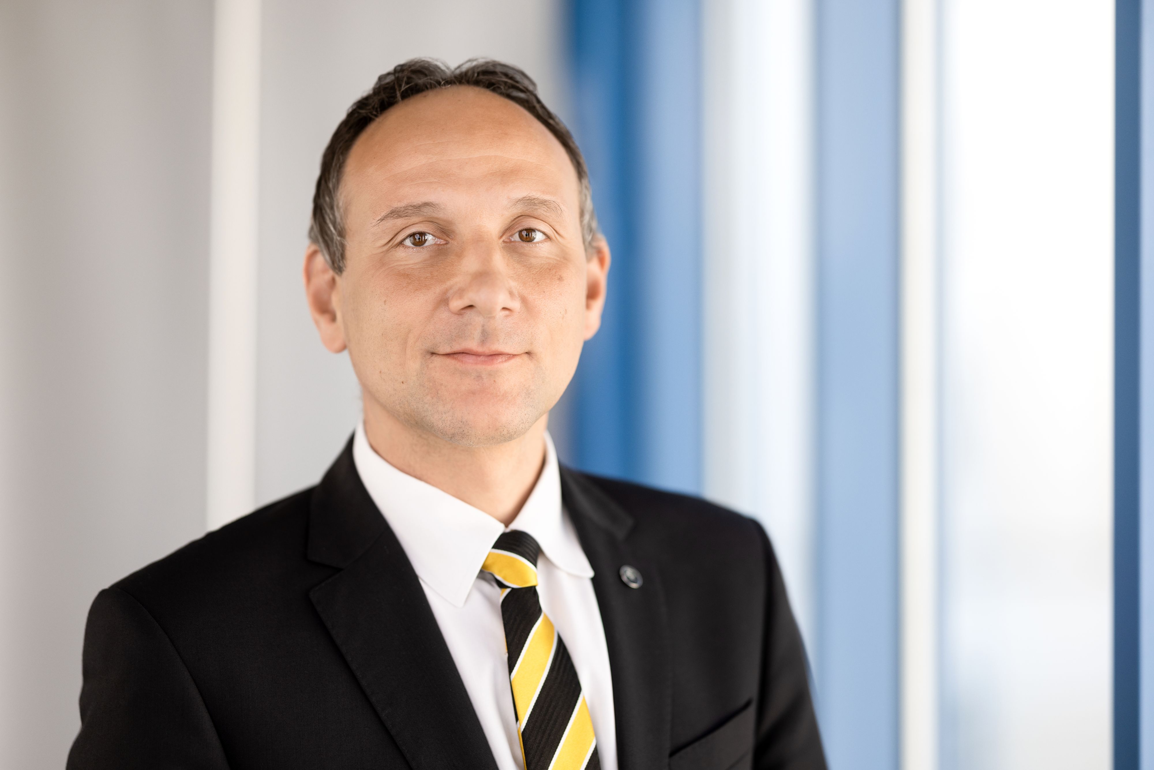 Ein Mann steht vor einem Fenster. Es ist Christian Dressel der erste Beigeordnete der Stadt Sonneberg.