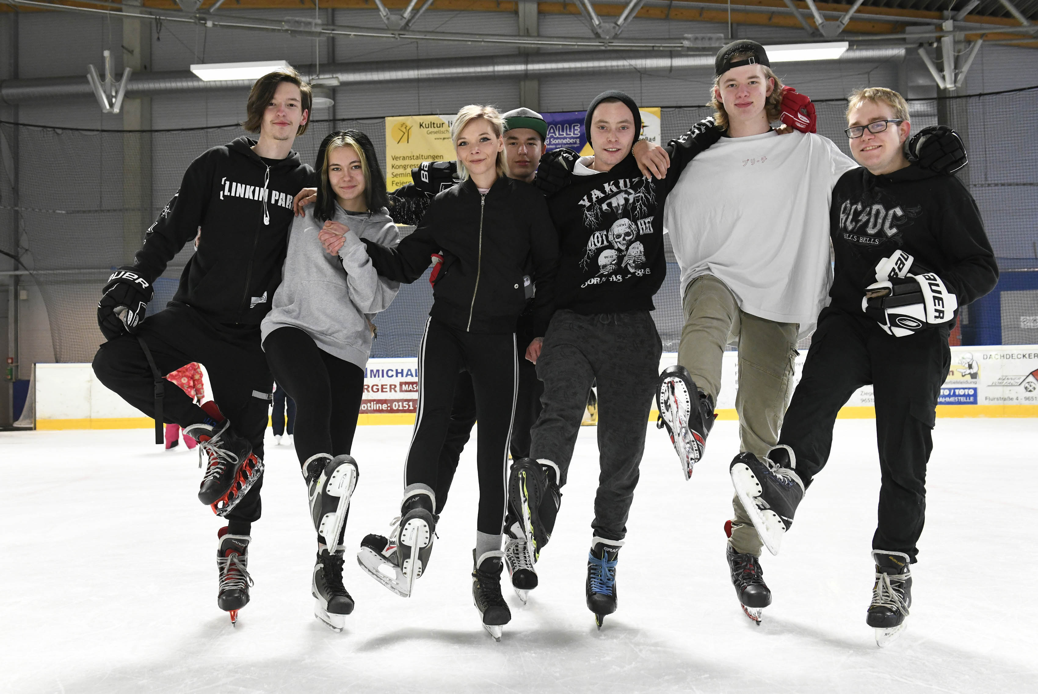 Mehrere Personen fahren Schlittschuh in der Eishalle.