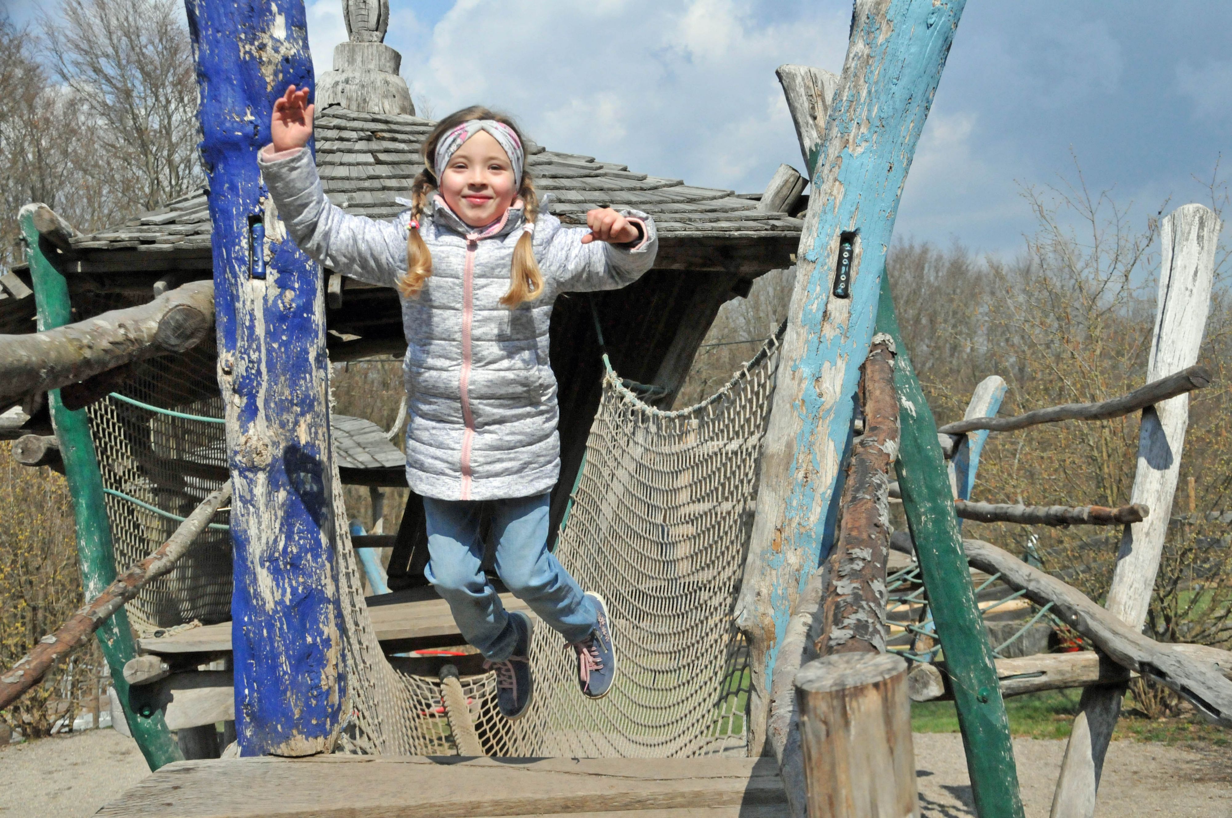 Ein spielt auf dem Klettergerüst im Tiergarten.
