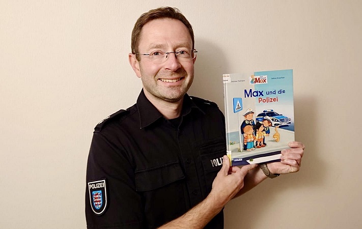 Polizeioberkommissar Martin Schreier hält das Buch Max und die Polizei