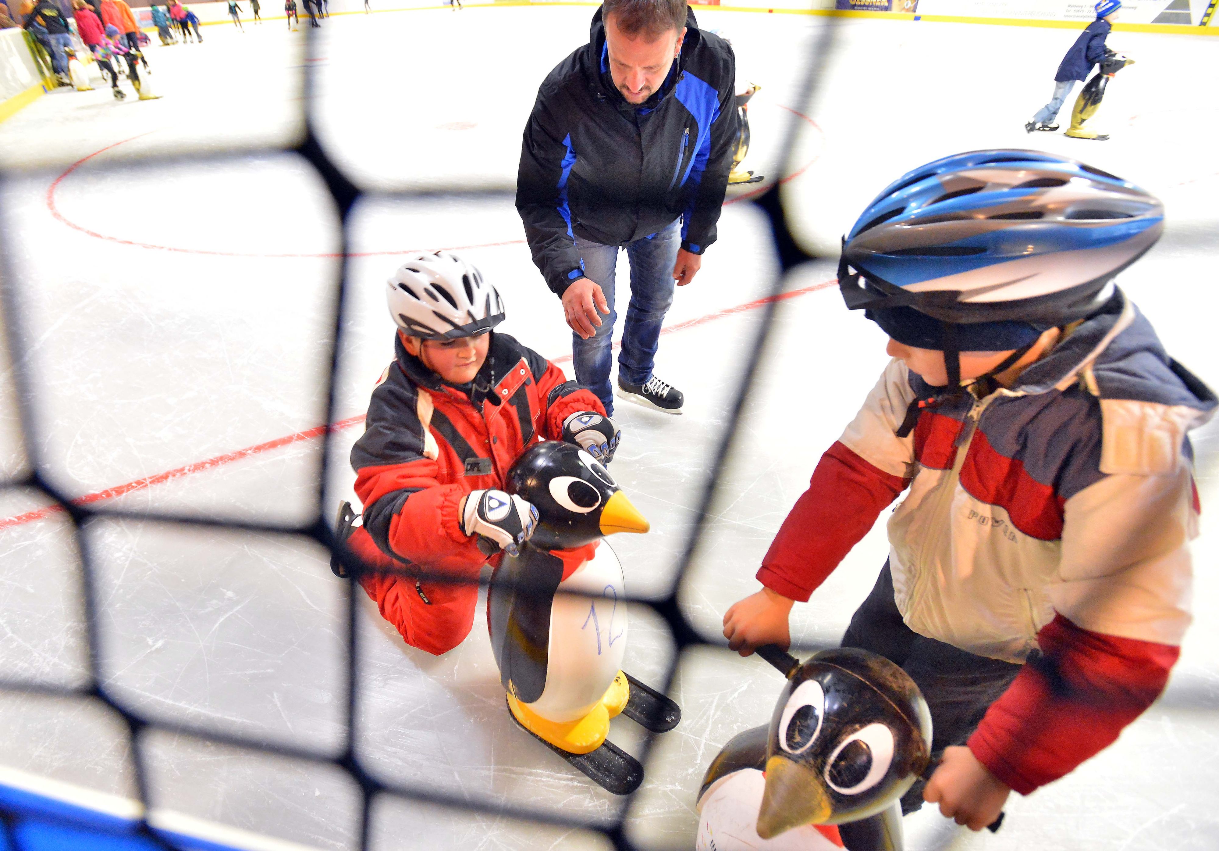 Kinder lernen Schlittschuh-Fahren.
