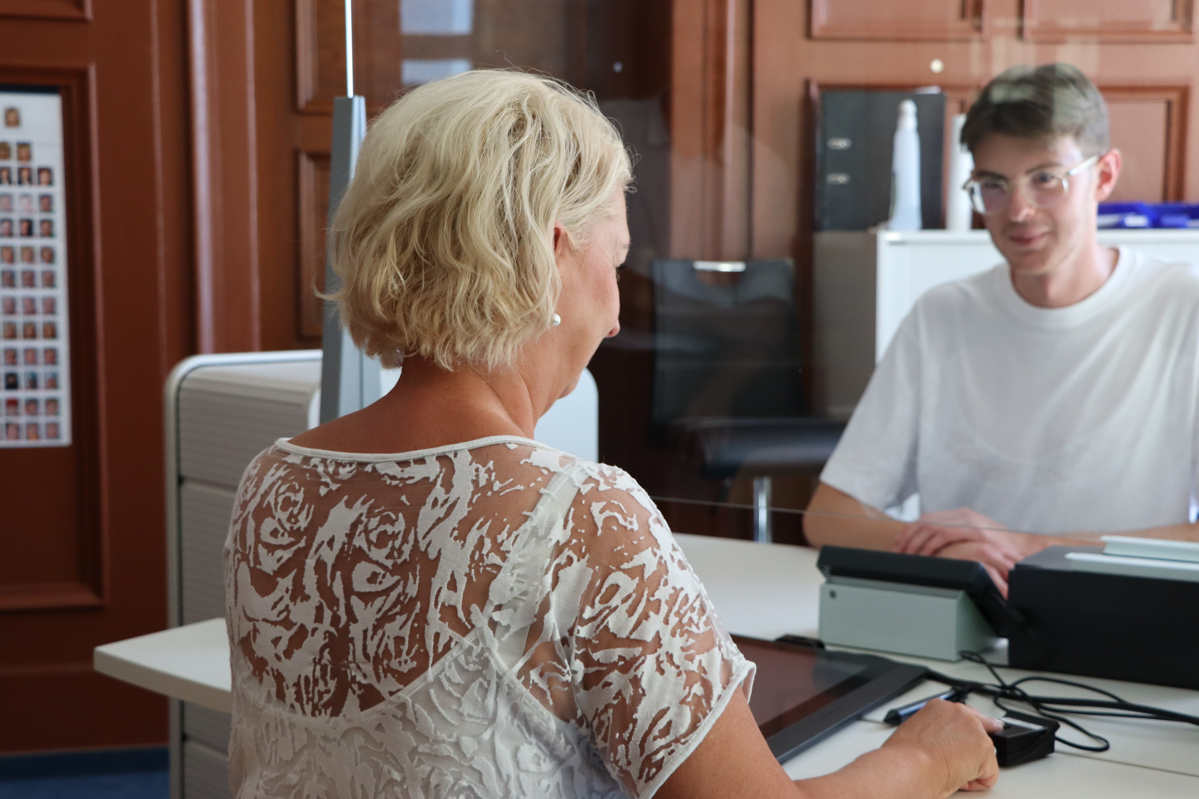 Eine Frau und ein Mann sitzen sich an einem Tisch im Büro gegenüber.
